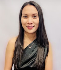 a woman in a black dress smiling for the camera